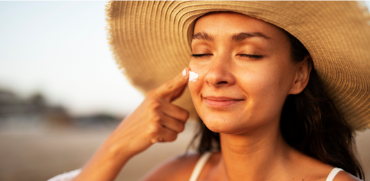 A woman applying sunscreen to her face
